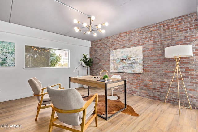 office featuring a notable chandelier, brick wall, and hardwood / wood-style flooring