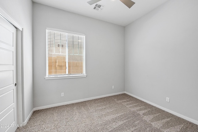 empty room featuring ceiling fan, plenty of natural light, and carpet