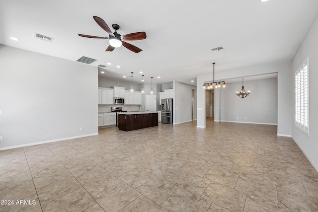 unfurnished living room with ceiling fan with notable chandelier