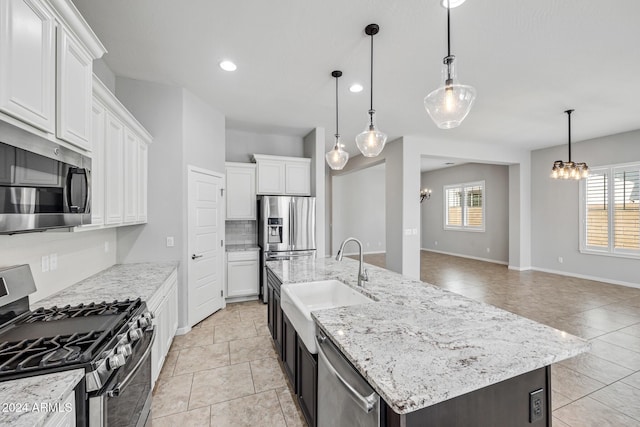 kitchen with white cabinetry, sink, hanging light fixtures, a center island with sink, and appliances with stainless steel finishes