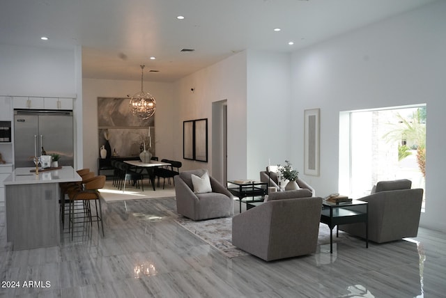 living room featuring a chandelier and a towering ceiling