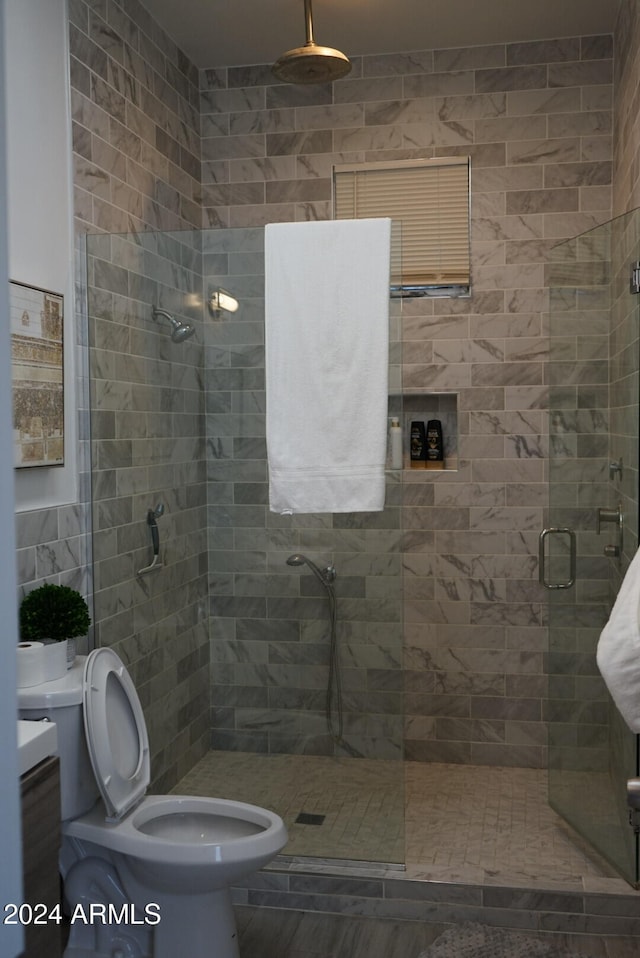 bathroom with tile walls, an enclosed shower, and toilet