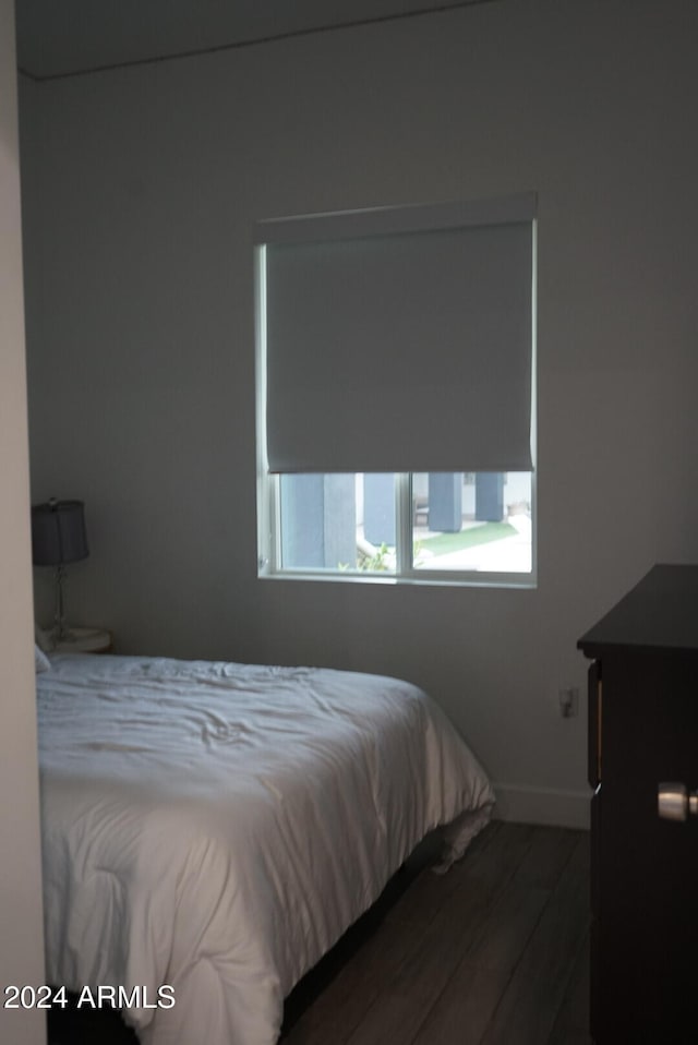 bedroom with dark hardwood / wood-style flooring