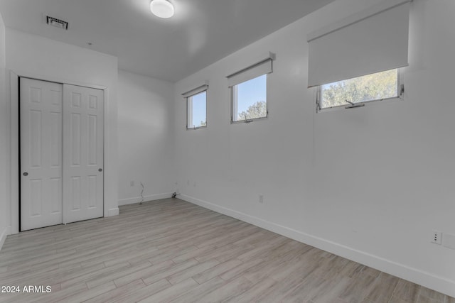 basement with light hardwood / wood-style flooring and a healthy amount of sunlight