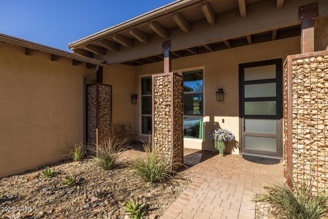 view of exterior entry with a patio area