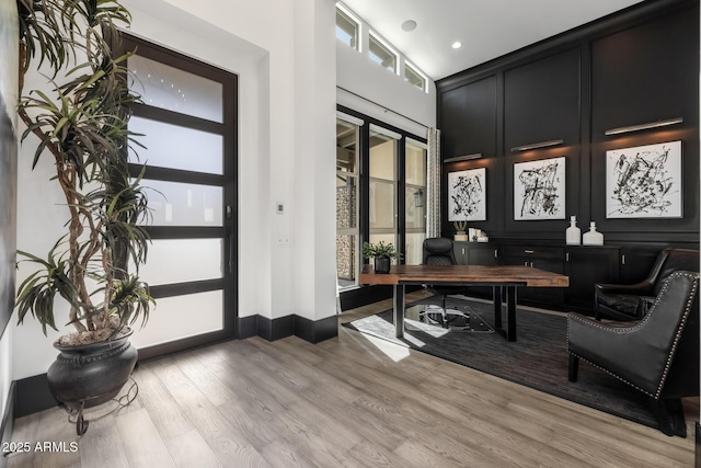 office area featuring a high ceiling and light wood-type flooring