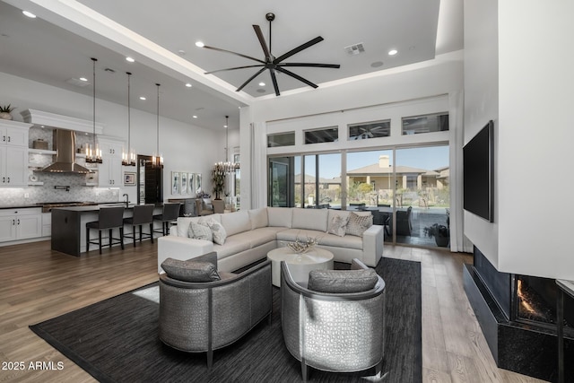 living room with a towering ceiling and light wood-type flooring