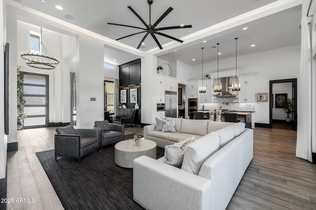 living room with dark hardwood / wood-style floors, a chandelier, and a high ceiling