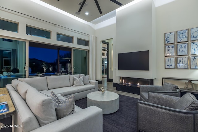 living room with a towering ceiling and ceiling fan