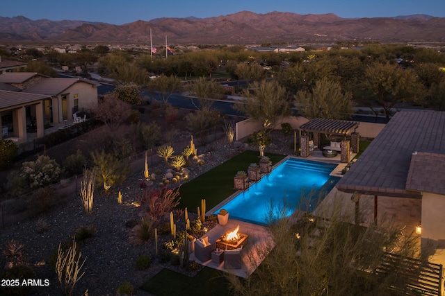 pool at dusk with a pergola, a fire pit, and a mountain view