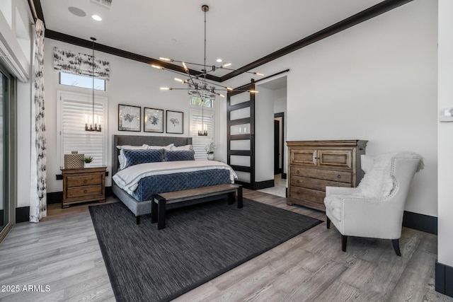 bedroom featuring multiple windows, ornamental molding, and light wood-type flooring