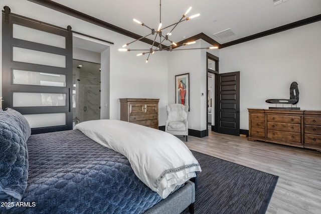 bedroom featuring hardwood / wood-style flooring, crown molding, and a barn door