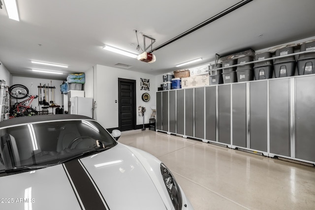 garage featuring a garage door opener and white fridge