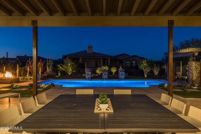 pool at night featuring a deck