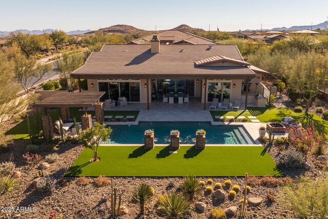 view of pool featuring a pergola, a mountain view, a patio area, and a lawn