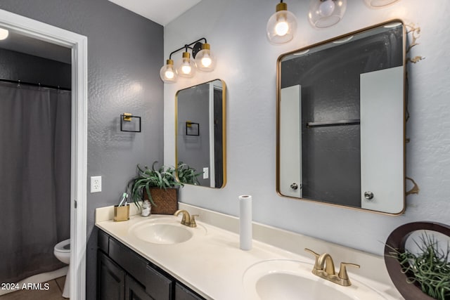 bathroom featuring walk in shower, toilet, and vanity