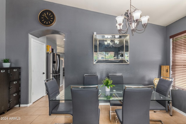 dining area with vaulted ceiling, a notable chandelier, and light tile patterned floors