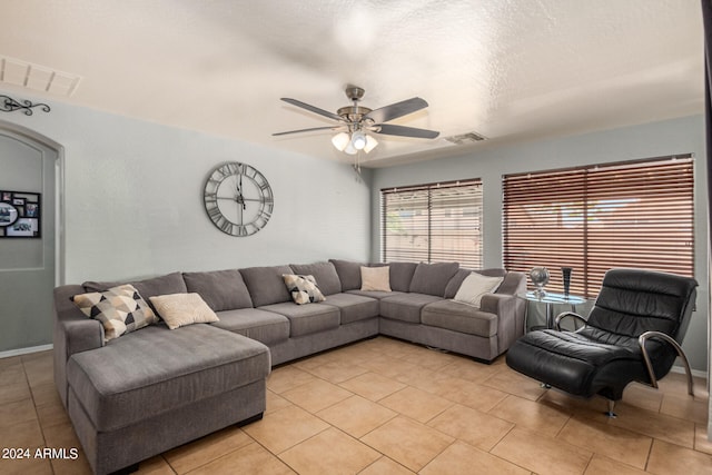 living room with ceiling fan and a textured ceiling