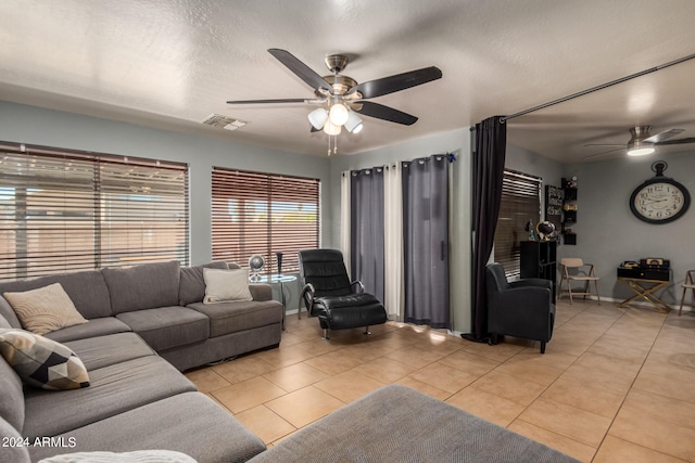 tiled living room with ceiling fan and a textured ceiling