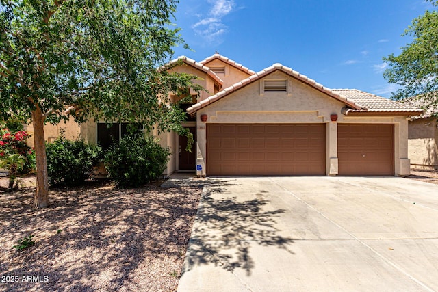 view of front facade with a garage, stucco siding, driveway, and a tile roof