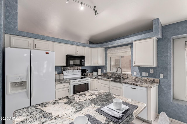 kitchen featuring light stone countertops, a sink, white appliances, white cabinetry, and baseboards