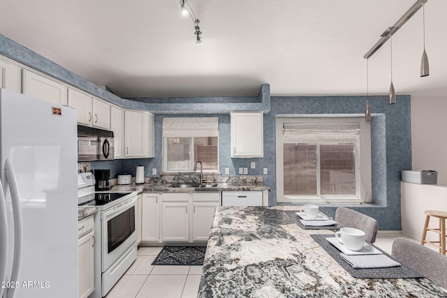 kitchen featuring light tile patterned flooring, white appliances, white cabinets, a sink, and stone counters
