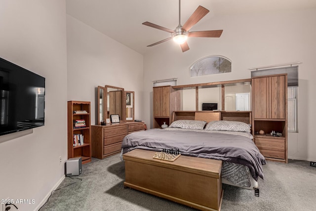 carpeted bedroom with baseboards, a ceiling fan, and high vaulted ceiling
