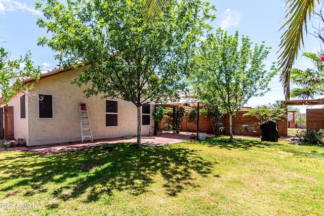 back of property featuring a fenced backyard, stucco siding, a yard, and a patio area