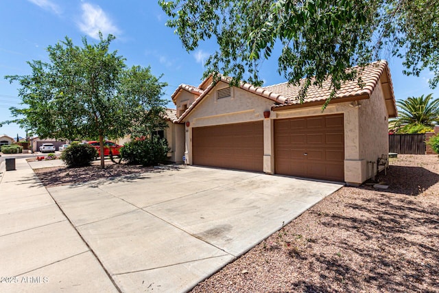 single story home with a garage, stucco siding, a tiled roof, and driveway