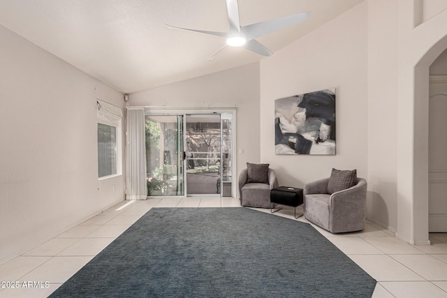 sitting room with arched walkways, ceiling fan, tile patterned floors, and vaulted ceiling