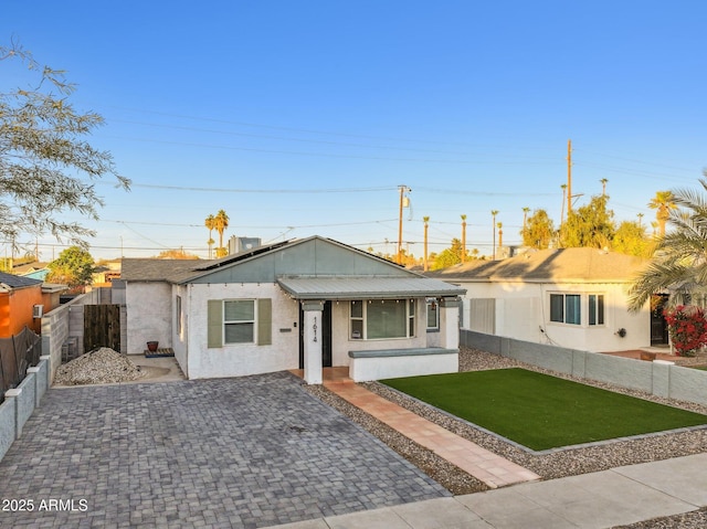 single story home featuring covered porch and a front lawn