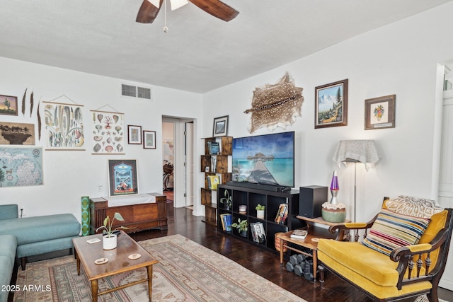 living room featuring ceiling fan, dark hardwood / wood-style flooring, and a textured ceiling