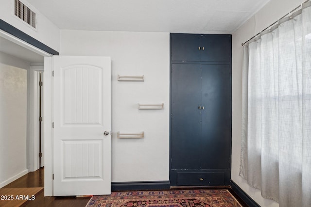 unfurnished bedroom with a closet and dark wood-type flooring