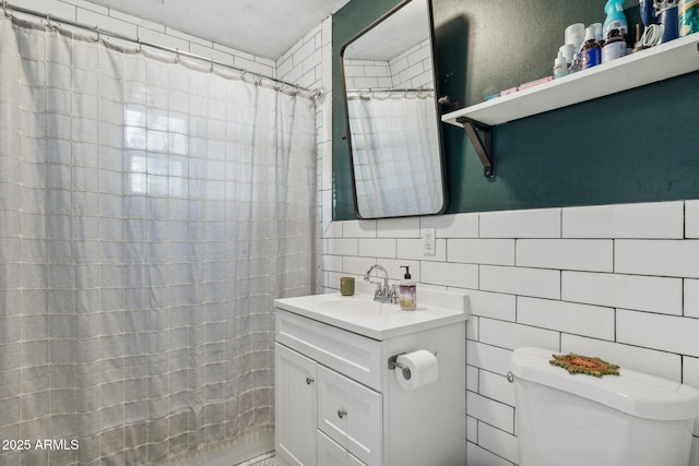 bathroom with vanity, toilet, and tile walls