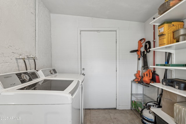 laundry room with washer and dryer and light tile patterned floors