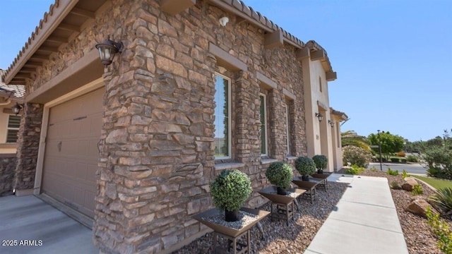 6917 E Ingram Cir, Mesa, AZ 85207 - view of side of property featuring stone siding, a garage, and driveway