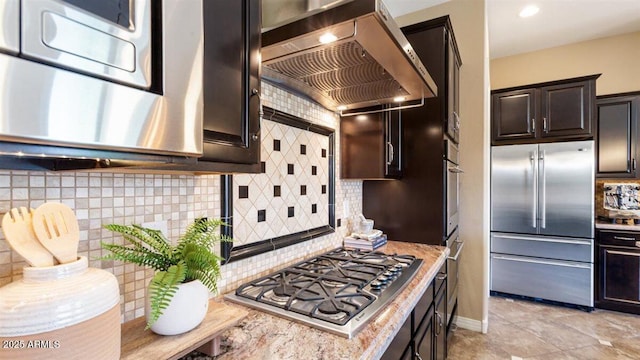 6917 E Ingram Cir, Mesa, AZ 85207 - kitchen with appliances with stainless steel finishes, wall chimney range hood, backsplash, dark brown cabinets, and light stone counters
