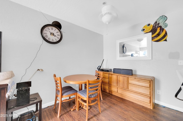 dining space with baseboards and wood finished floors