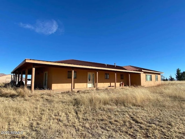back of property featuring metal roof