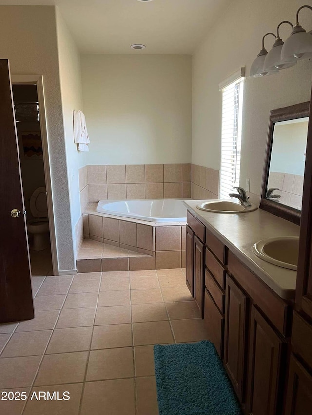 bathroom featuring double vanity, tile patterned floors, a sink, and a bath