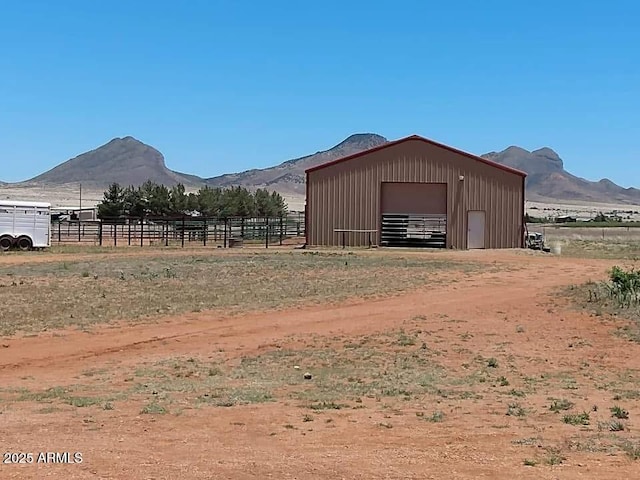 view of pole building with fence and a mountain view