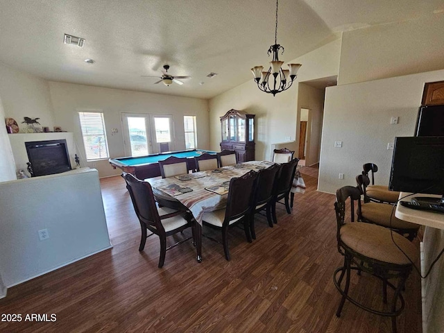interior space featuring dark wood-style flooring, a textured ceiling, visible vents, and a glass covered fireplace