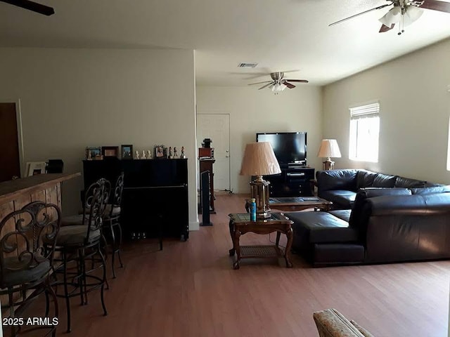 living room featuring a ceiling fan, wood finished floors, and visible vents