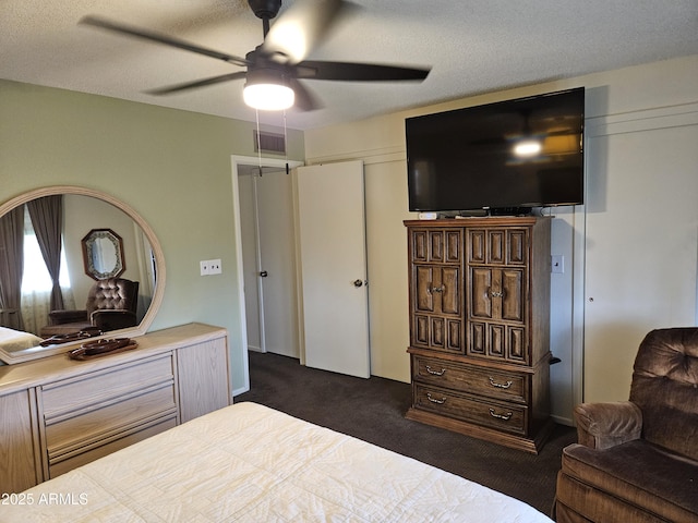 bedroom featuring visible vents, a ceiling fan, and dark colored carpet
