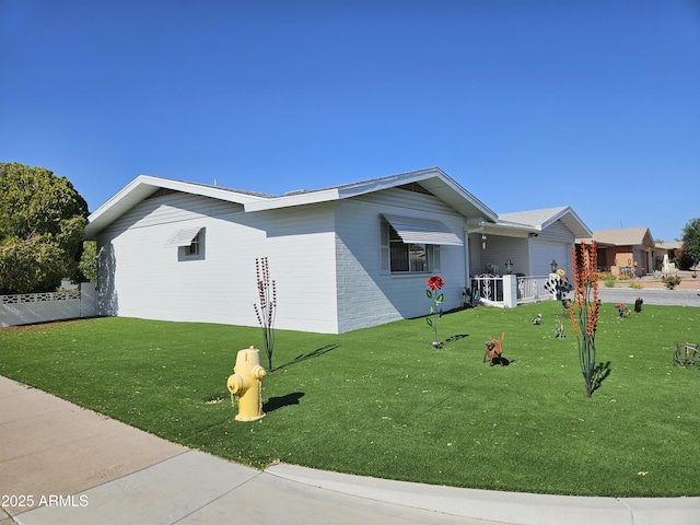 view of front facade featuring an attached garage, fence, and a front lawn
