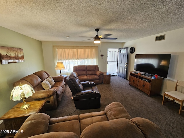 living room featuring a ceiling fan, dark colored carpet, a textured ceiling, and visible vents