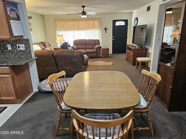 dining area with visible vents, a textured ceiling, ceiling fan, and light colored carpet
