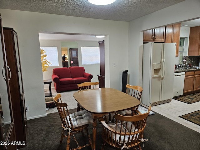 dining area featuring a textured ceiling and light tile patterned flooring
