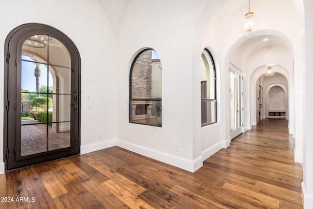 foyer featuring a notable chandelier, hardwood / wood-style floors, and high vaulted ceiling