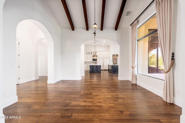 unfurnished living room featuring beam ceiling and dark hardwood / wood-style flooring